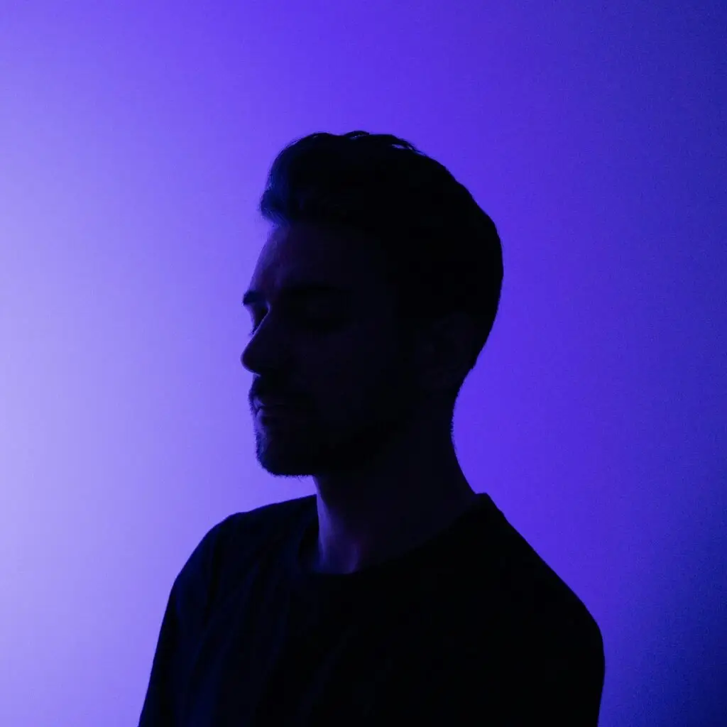 a man standing in front of a purple wall